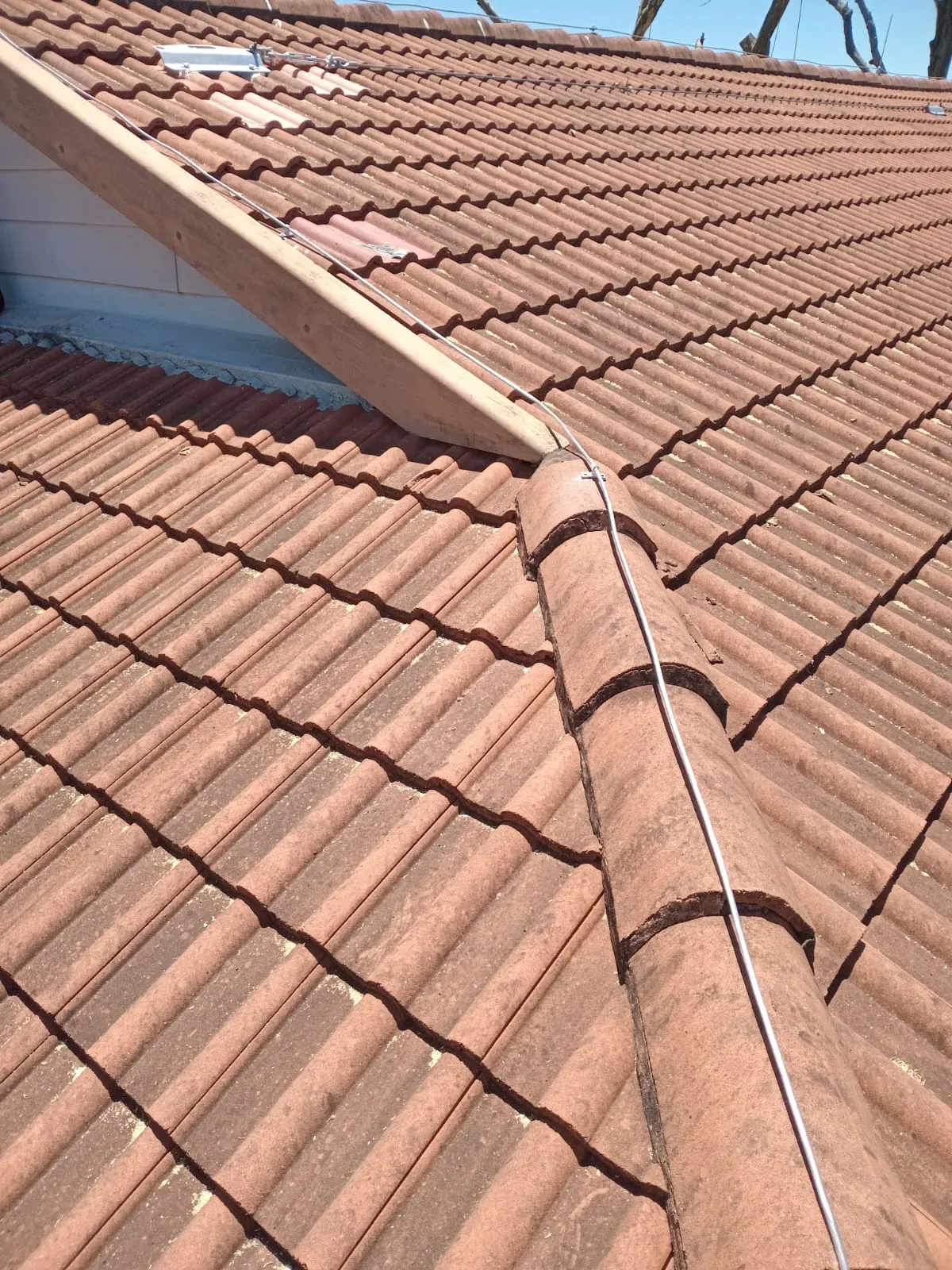 Lightning protection system conductors and fittings on a tiled roof.